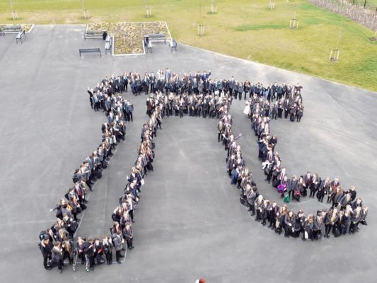LAR students form the shape of the Pi symbol for an aerial photo in the school playground.